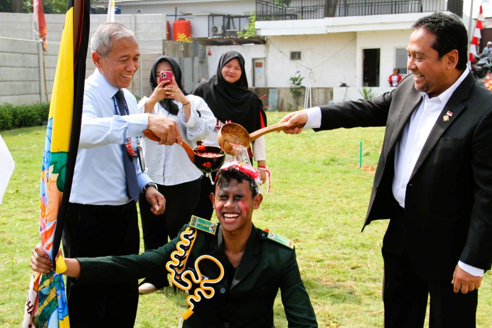 Ketua Umum Yayasan Sumber Setia Berkah dan Kepala BPH Labschool Ciracas Hariyadi Sukamdani (kanan) menyiramkan air ke pengurus MPK dan OSIS SMA Labschool Ciracas sebagai rangkaian dari prosesi Lari Lintas Juang dan prosesi pelantikan pengurus MPK dan OSIS SMA Labschool Ciracas dengan disaksikan oleh Kepala Sekolah SMA Labschool Ciracas Risang Danardana (kiri) pada Senin, 17 Agustus 2026 di lapangan SMA Labschool Ciracas.